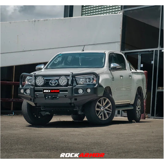 White pickup truck with aftermarket elite bull bar and fog lights on Toyota Hilux N80