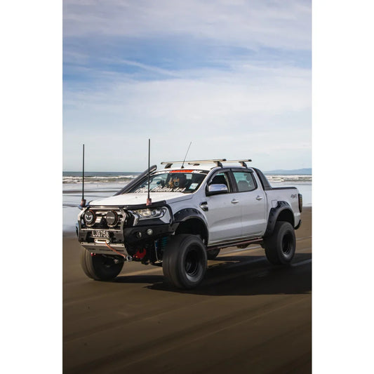 Modified white pickup truck with Rockarmor GT Steel Hoop Bullbar, driving lights, and fog lights