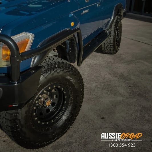Blue off-road vehicle with steel checker plate bull bar and black wheels on Toyota Landcruiser