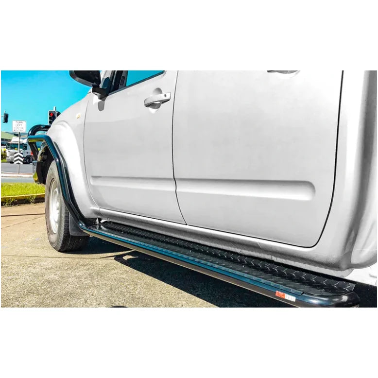 Silver pickup truck with black running boards featuring Rockarmor Brushbar for Nissan Navara