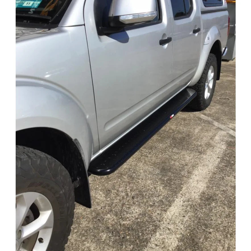Silver pickup truck featuring black running board with Rockarmor Brushbar for Nissan Navara D40