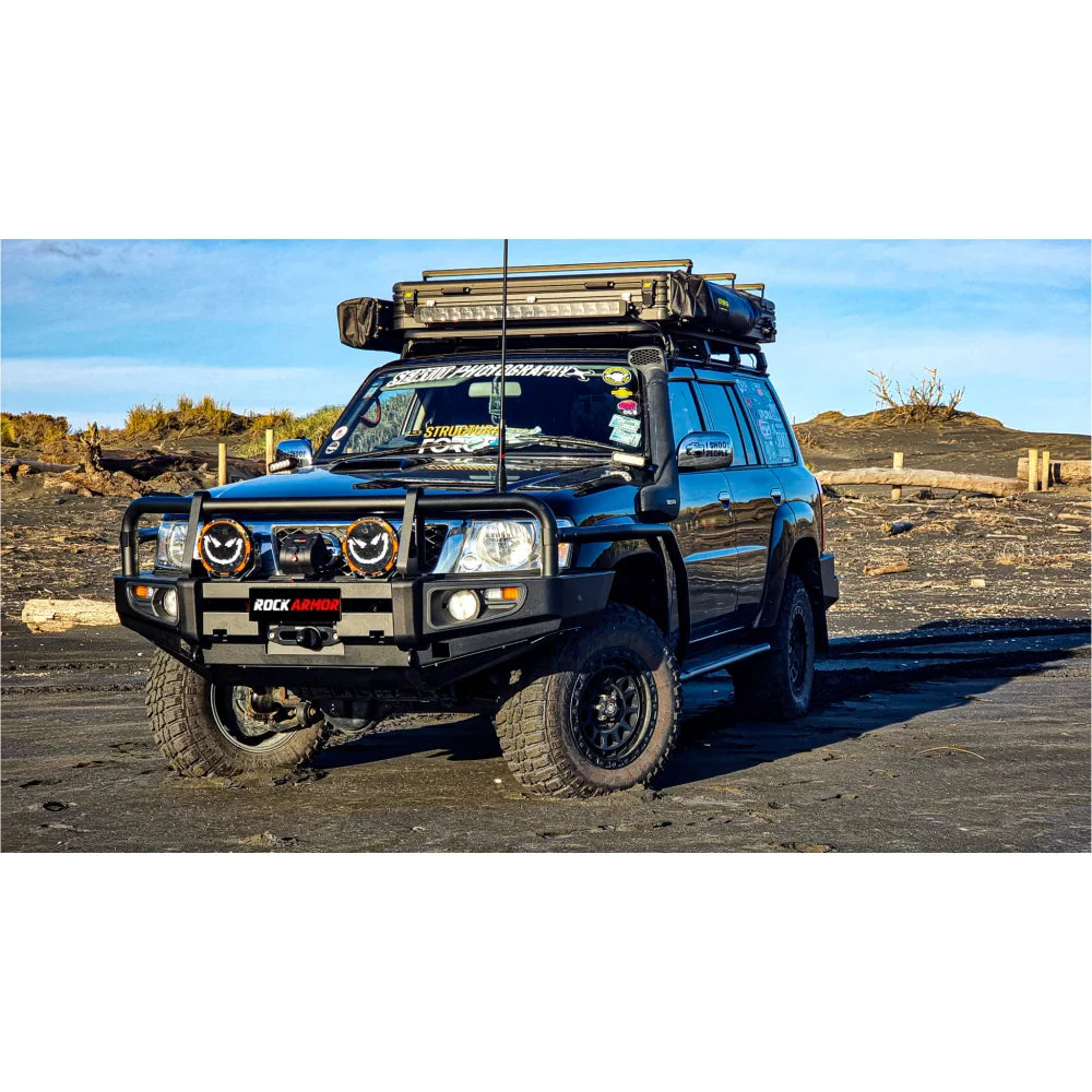 Black off-road vehicle with roof rack featuring Rockarmor Brushbar for Nissan Patrol GU1