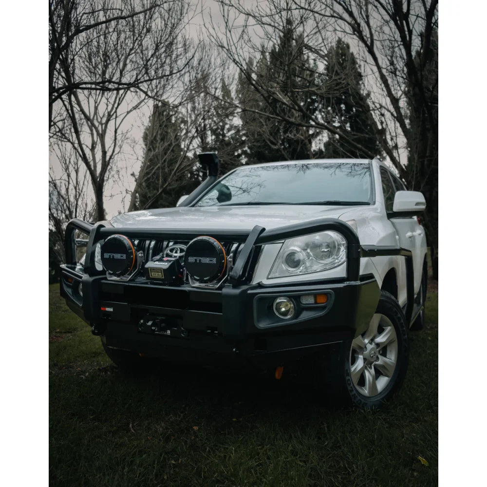 White off-road vehicle with black bull bar featuring Rockarmor Brushbar in premium steel