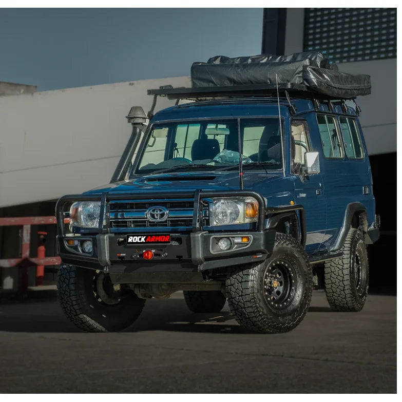 Blue off-road vehicle with roof tent featuring Rockarmor Brushbar and premium steel design