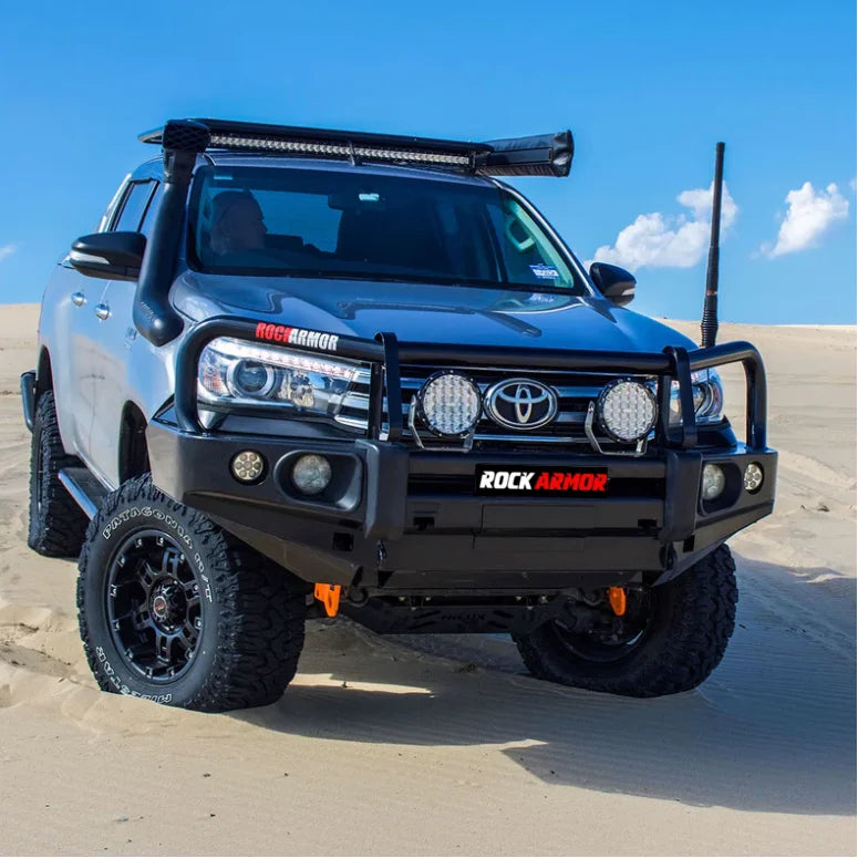 Silver Toyota Hilux with aftermarket bull bar and fog lights, suitable for off-road use