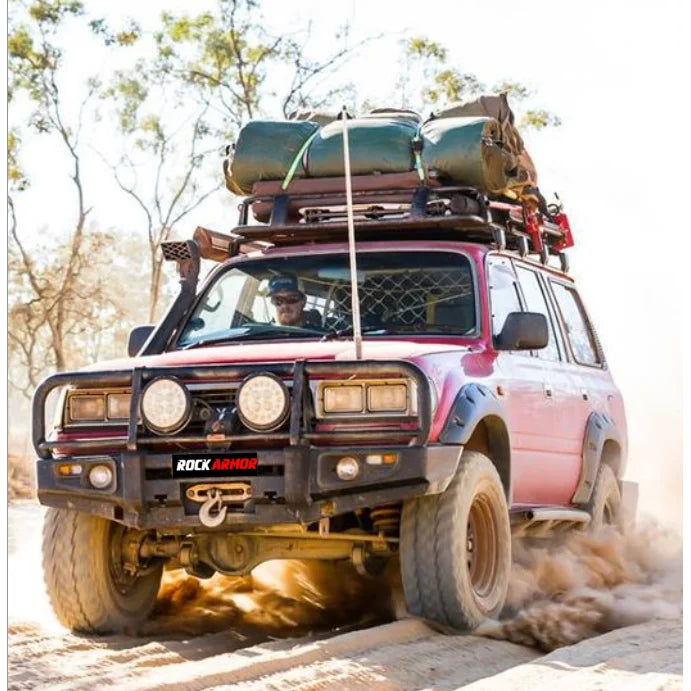 Red off-road vehicle with steel bullbar and fog lights on roof rack for Toyota Landcruiser FJ80
